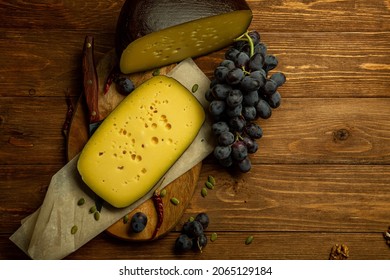 composition of different types of sliced cheese: hard, mature, cheese with mold. Cheese slicing with fruit - grapes and figs. concept is cheese handicraft production
