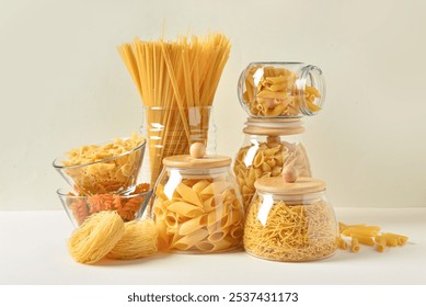 Composition with different uncooked pasta in glass bowls on light background - Powered by Shutterstock