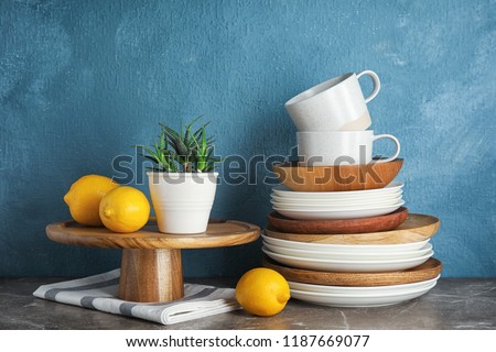 Composition with dinnerware on table against color background. Interior element