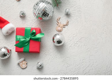 Composition with disco balls, gift box and Christmas decor on white grunge background