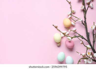 Composition with Easter eggs and blooming tree branches on pink background