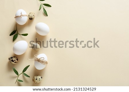 Composition with Easter eggs and green branches on beige background