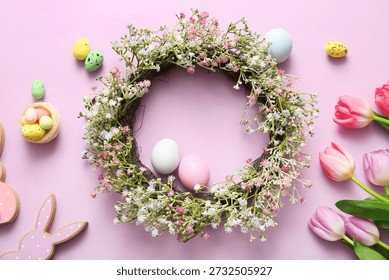 Composition with Easter wreath, flowers and eggs on lilac background, closeup