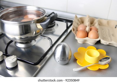 composition of eggs, stew pan, egg shape timer, eggcup end eggcartoon in the kitchen