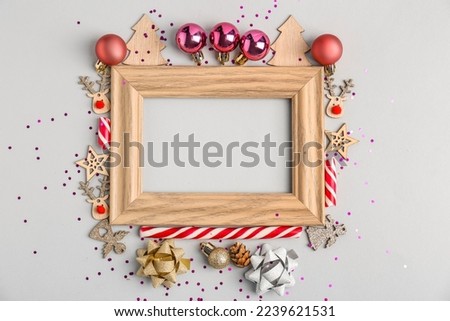 Composition with empty picture frame and Christmas decorations on white background