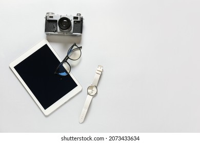 Composition with eyeglasses and tablet computer on light background