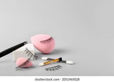 Composition with false eyelashes and tools on grey background