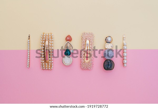 Composition of fashion\
accessories and hair clips for a hairstyle stylist on a pastel\
yellow and pink\
background