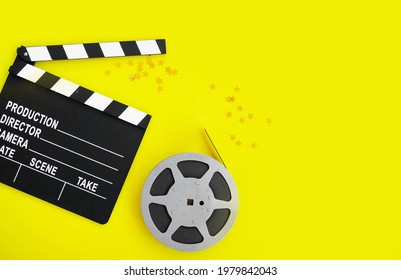 Composition With Film Strip, Clapperboard And Confetti Gold Stars On Yellow Background. Concept Movie Night, Cinema. Flatlay. Copy Space. Top View