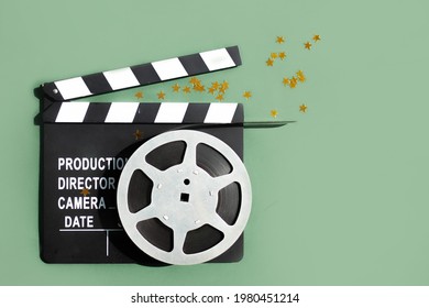 Composition With Film Strip, Clapperboard And Confetti Gold Stars On Green Background. Concept Movie Night, Cinema. Flatlay. Copy Space. Top View