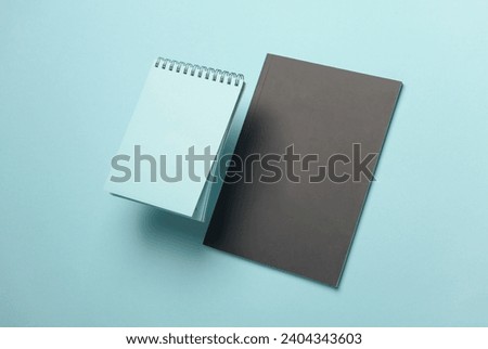 Composition of floating notepads on a blue background