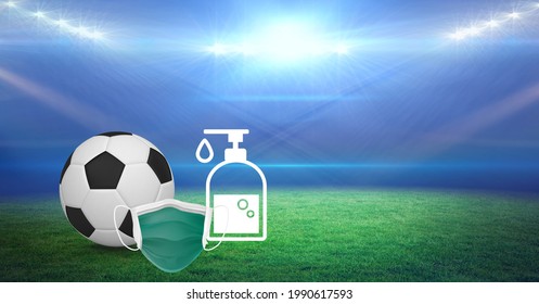 Composition Of Football, Face Mask And Disinfectant Over Sports Stadium. Sports And Competition During Covid 19 Pandemic Concept Digitally Generated Image. ,