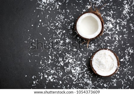 Composition with fresh coconut flakes on dark background, top view