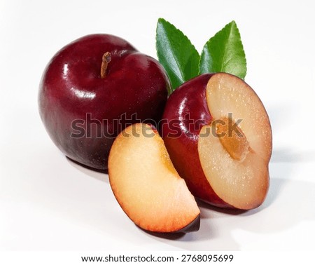Composition of fresh raw damson plums shot on white relective surface