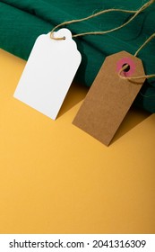 Composition of gift tags with copy space and green fabric on yellow background. christmas, gifts, tradition and celebration concept.