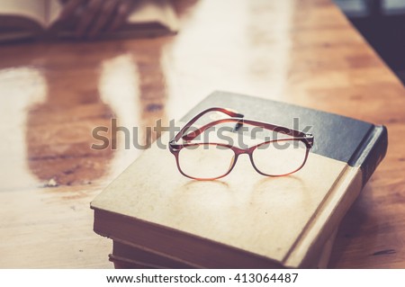  Composition with glasses and book for world philosophy, on wood table, iteracy day concept.