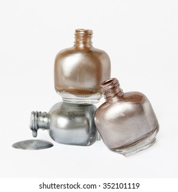 Composition Of Gold Silver And Pink Nail Polish Bottle On White Background