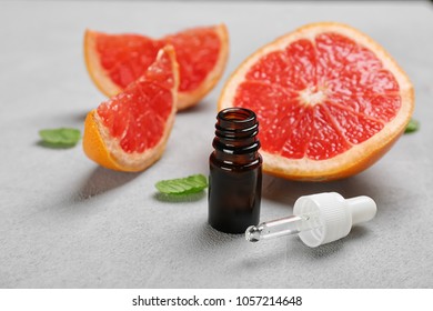 Composition with grapefruit essential oil on grey background