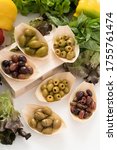 
Composition of green, black olives, stuffed with peppers, pitted olives and beautiful Cerignola olives in bamboo bowls