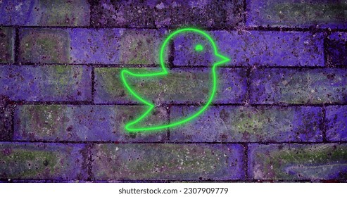 Composition of green neon bird icon on brick wall. Social media, communication and digital interface concept digitally generated image. - Powered by Shutterstock