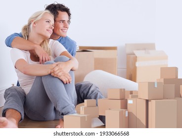 Composition of happy couple embracing surrounded by cardboard boxes in new home. moving house, global shipment and delivery concept digitally generated image.