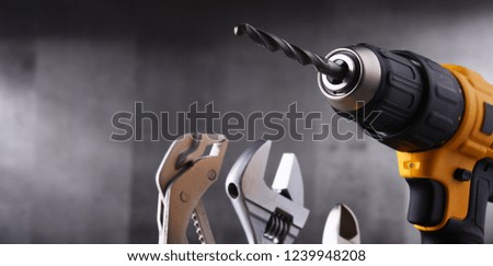 Composition with hardware tools including cordless drill and monkey spanner