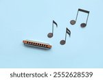 Composition with harmonica and music notes on color background