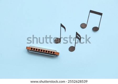 Composition with harmonica and music notes on color background