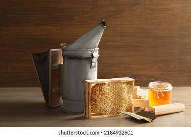 Composition With Honeycomb And Beekeeping Tools On Wooden Table