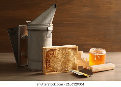 Composition With Honeycomb And Beekeeping Tools On Wooden Table