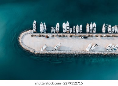 	 The composition of the image creates a beautiful abstract pattern that draws the viewer's eye to the different shades of blue and green water, as well as the boats lining the shoreline.	
