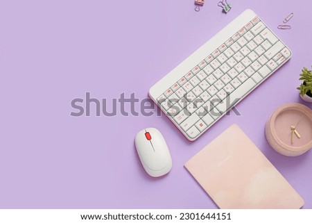 Composition with keyboard, mouse, clock and notebook on lilac background
