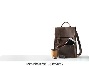 Composition with leather backpack, coffee and smartphone isolated on white