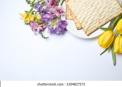 Composition with matzo and flowers on white background, top view. Passover (Pesach) Seder