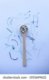 Composition Of Microplastic Fibers Collected From The Ocean On A Blue Background With A Wooden Spoon