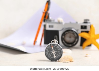 Composition with modern compass and seashell on beige background, closeup