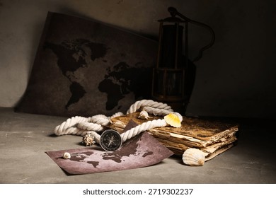 Composition with modern compass, world map, old book, rope and seashells on grey grunge background