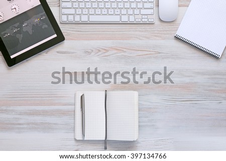 Composition with modern Electronics and Stationery Items in Wood Background Computer Keyboard Mouse Tablet PC and Notepad top View