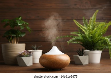 Composition with modern essential oil diffuser on wooden table against brown background, space for text - Shutterstock ID 1466168675