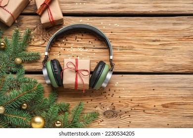 Composition with modern headphones, Christmas gifts and fir branches on wooden background - Shutterstock ID 2230534205