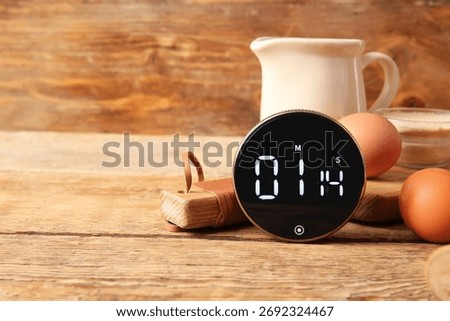 Composition with modern kitchen timer, dishware and ingredients on wooden background