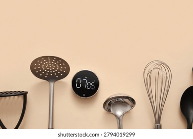 Composition with modern kitchen timer and utensils on beige background