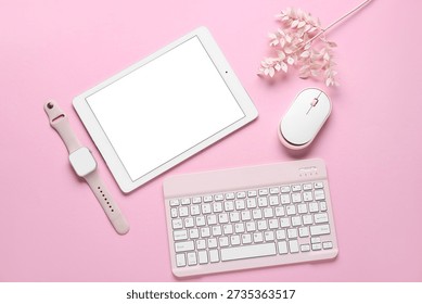 Composition with modern tablet computer, smart watch, PC mouse, keyboard and decorative flowers on pink background
