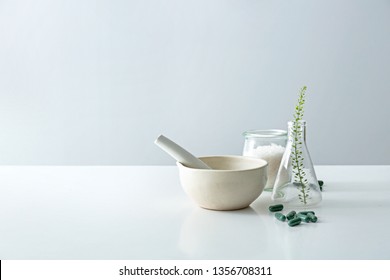 Composition with mortar, flask and plant based pills on table