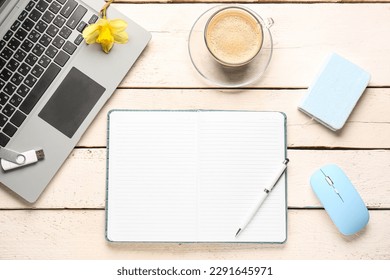 Composition with notebook, laptop, mouse and cup of coffee on white wooden table