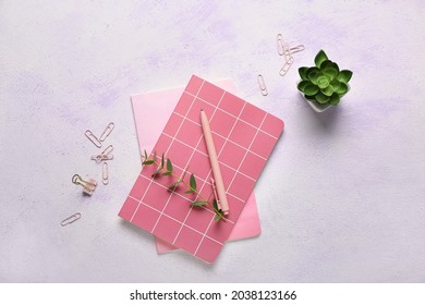 Composition with notebooks, pen, clips and houseplant on color background