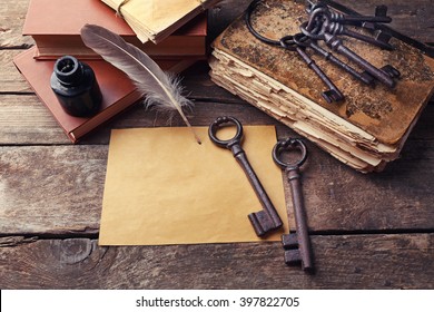 Composition of old books, keys and other things on wooden background, close up