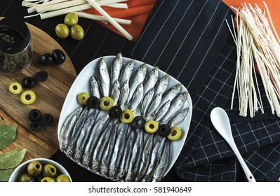 The composition on the table of the little fish and olives