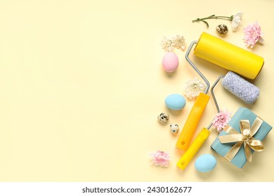 Composition with paint rollers, gift box, flowers and Easter eggs on color background