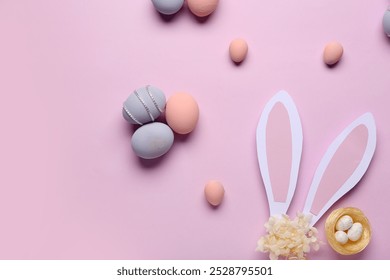 Composition with painted Easter eggs, nest and paper bunny ears on purple background - Powered by Shutterstock